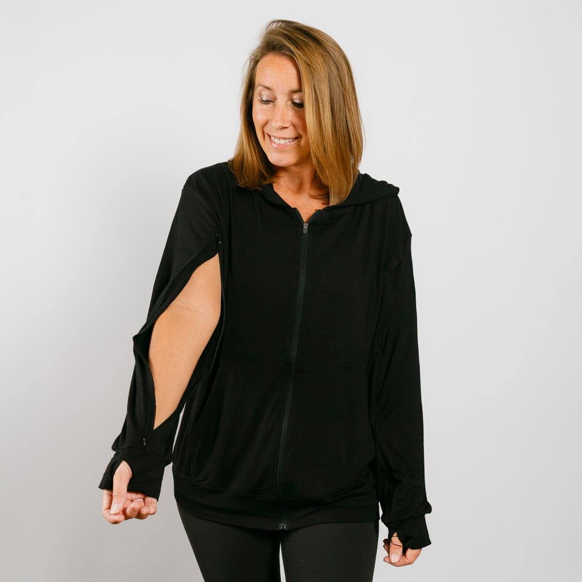 #NEW Woman wearing a black hoodie with cut-out sleeves on a plain background | Model is 5'3" 130lbs wearing size S