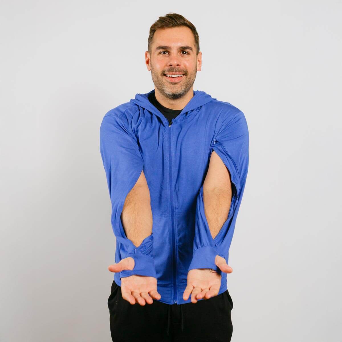 Man wearing a blue hoodie with cut-out sleeves on a plain background | Model is 5'8" 165lbs wearing size M