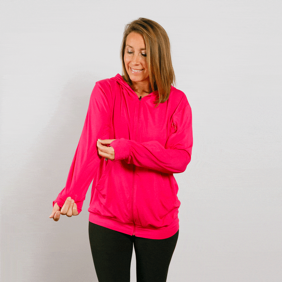 Woman wearing bright pink IV zip hoodie with front zipper, standing in lifestyle pose.
