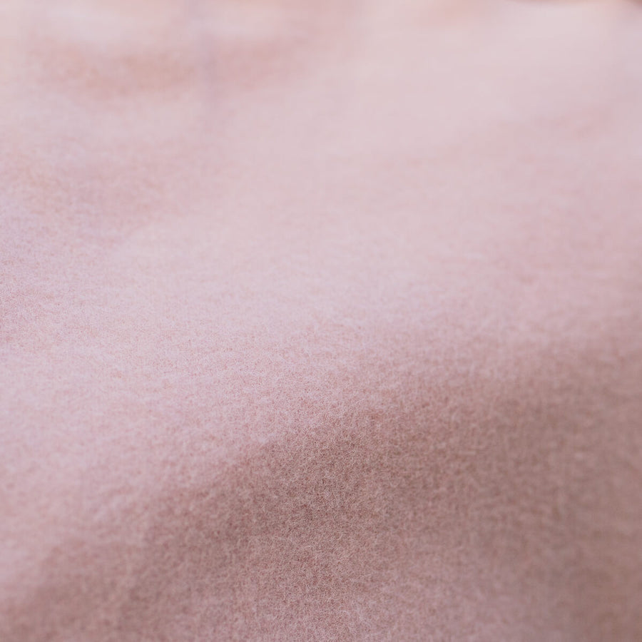 Close-up of blush pink IV zip hoodie fabric showing soft, textured material detail.