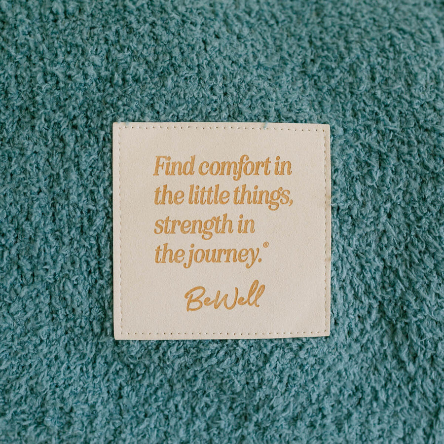 Close-up of inspirational quote patch on teal infusion day blanket.