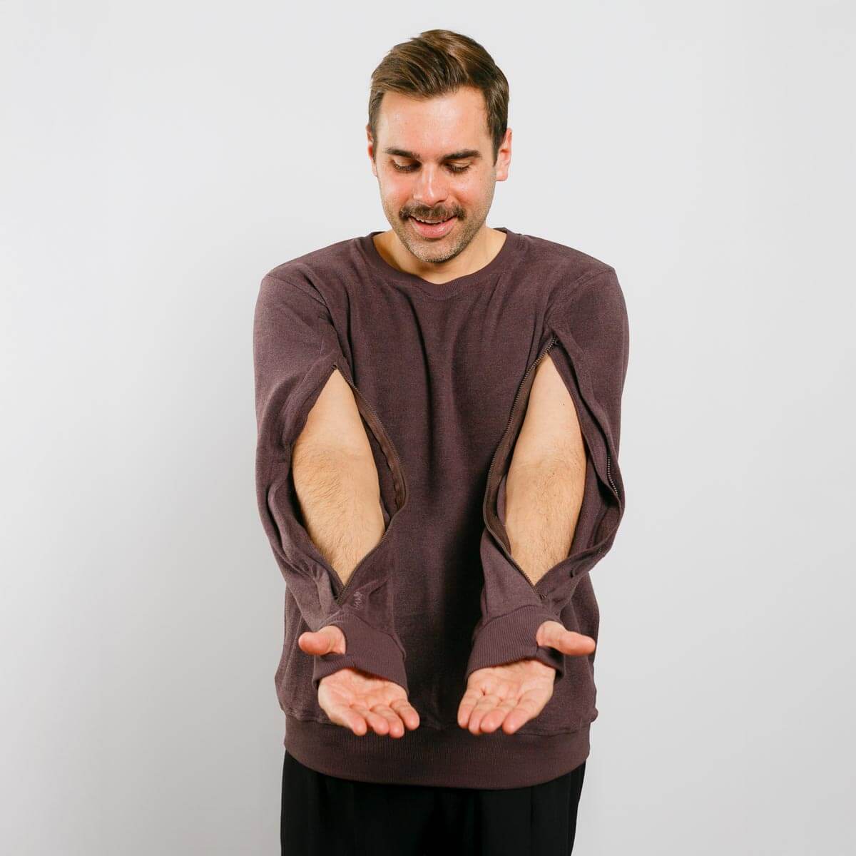 Man wearing a brown sweatshirt with cut-out design on a plain background | Model is 5'8" 165lbs wearing size M