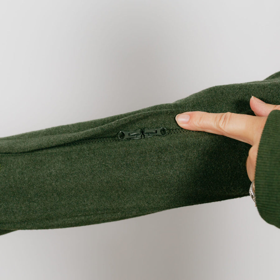 Close-up of olive green crewneck sleeve showing hidden zipper opening for IV access.