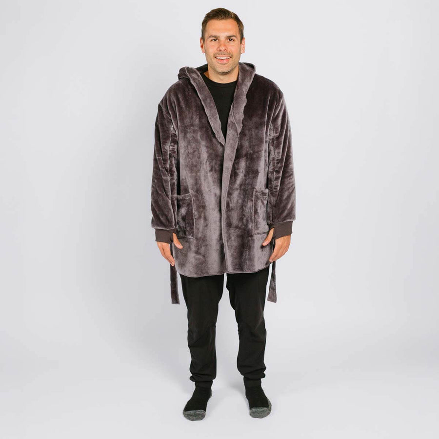 Man wearing a gray velvet hooded robe over black clothing against a white background.