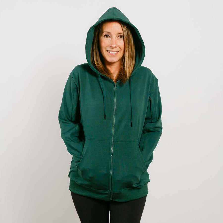 Woman wearing a dark green zip-up hoodie with drawstrings and front pockets against a white background.