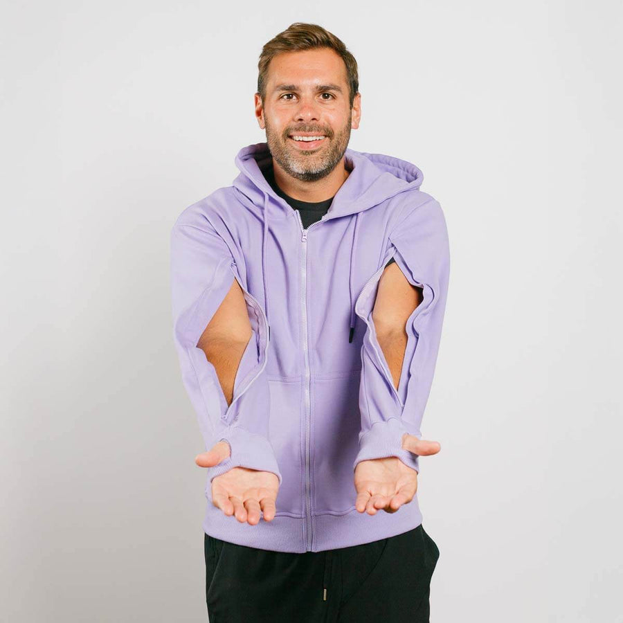 Man wearing lavender zip hoodie with large cutout holes on sleeves, posed against white background.