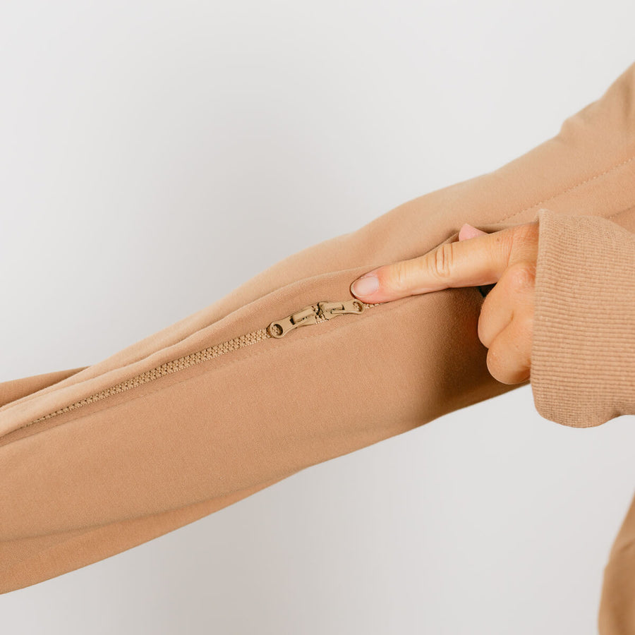Close-up of beige IV zip hoodie sleeve zipper showing arm access opening detail.