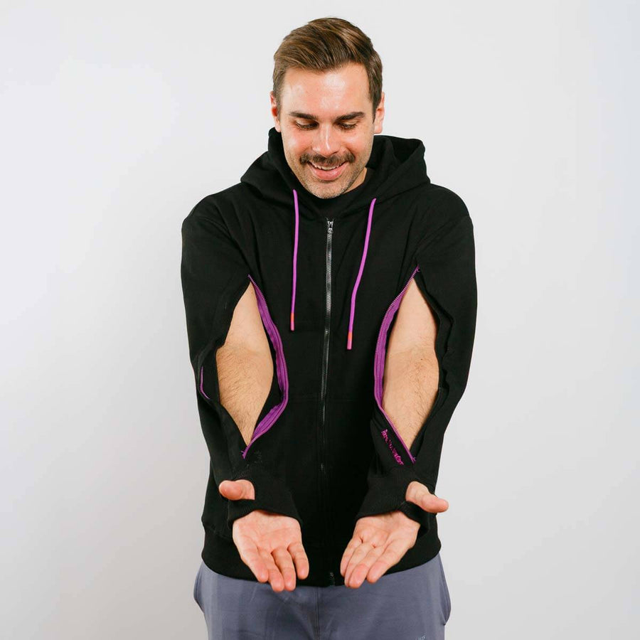 Man wearing a black sleeveless hoodie with purple accents on a plain background