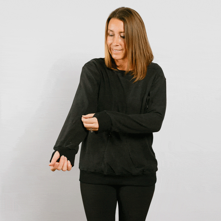 Woman wearing black crew neck sweatshirt with adaptive side zipper access, front view.