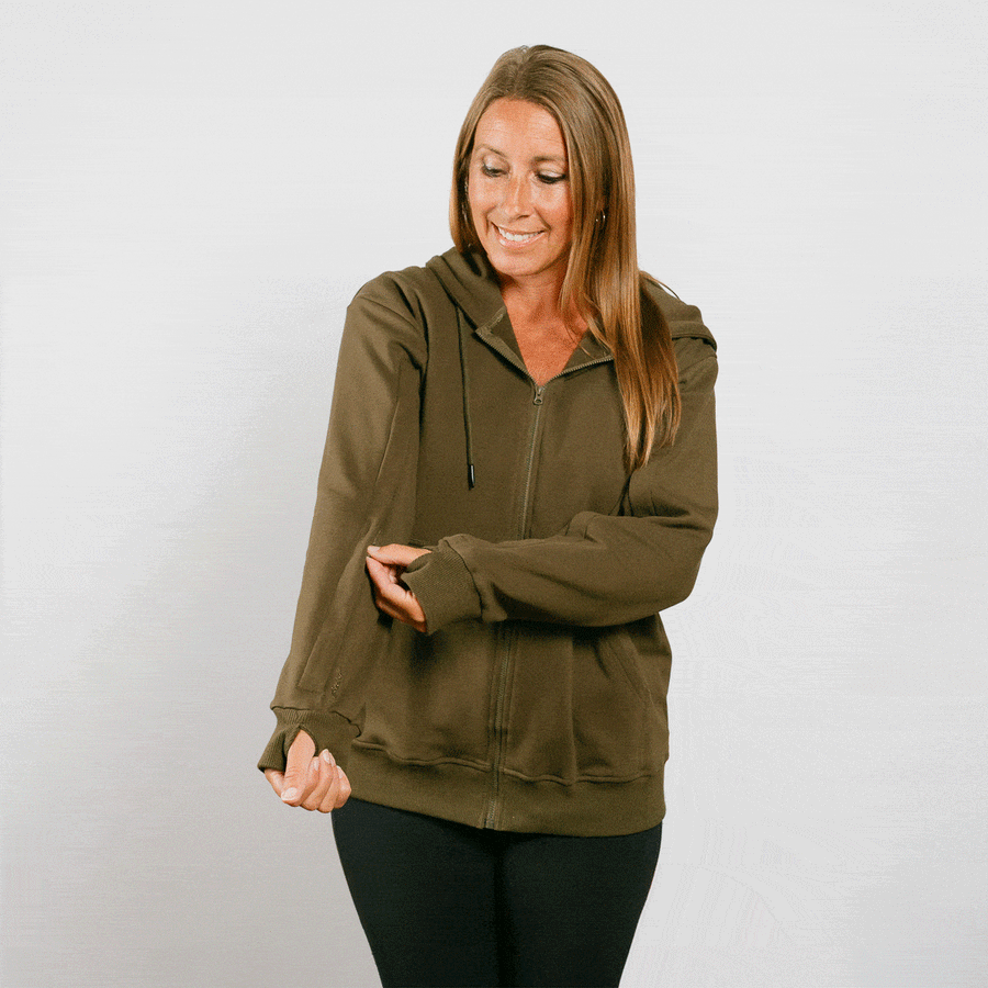 Woman wearing olive green IV zip hoodie with accessible zipper design during treatment.
