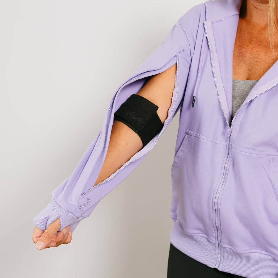 Woman wearing lavender wrap with open left sleeve showing black arm band access port.