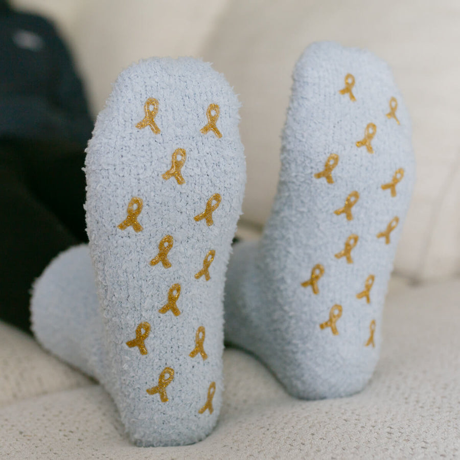 Light gray rest day socks with gold ribbon pattern, close-up front view.