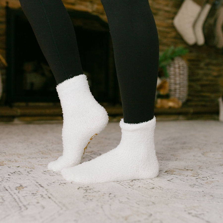 Person wearing white rest day socks with black leggings, standing on concrete ground.