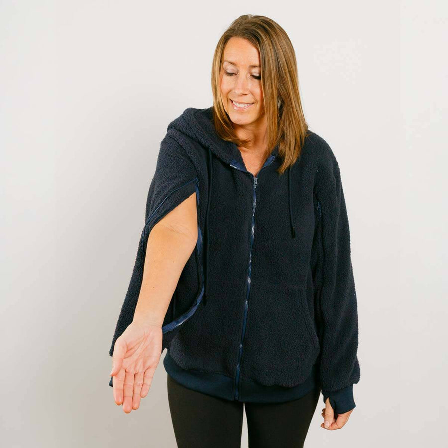 Woman wearing dark navy sherpa zip hoodie with left sleeve zipper open, shown from front.