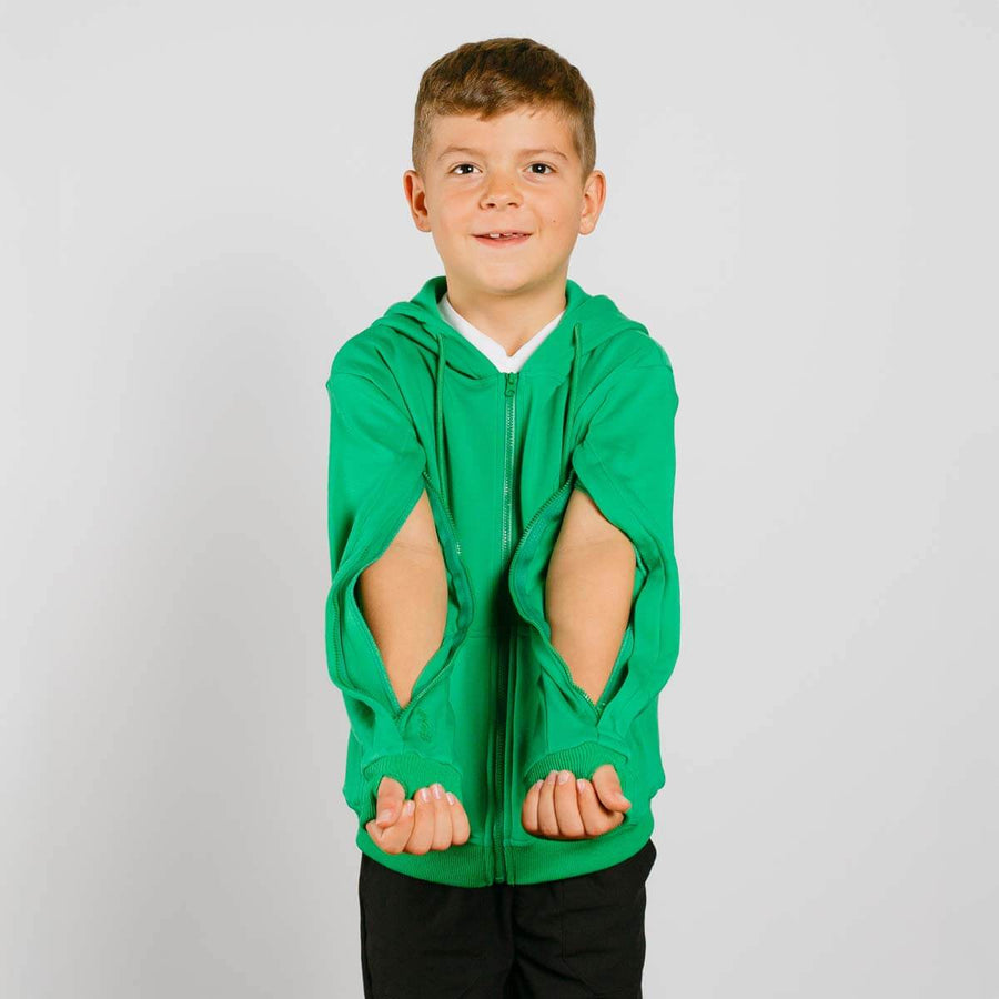 Young boy wearing a green zip hoodie with cutout sleeves over black pants. #NEW Child wearing a green hoodie with cut-out design on a plain background