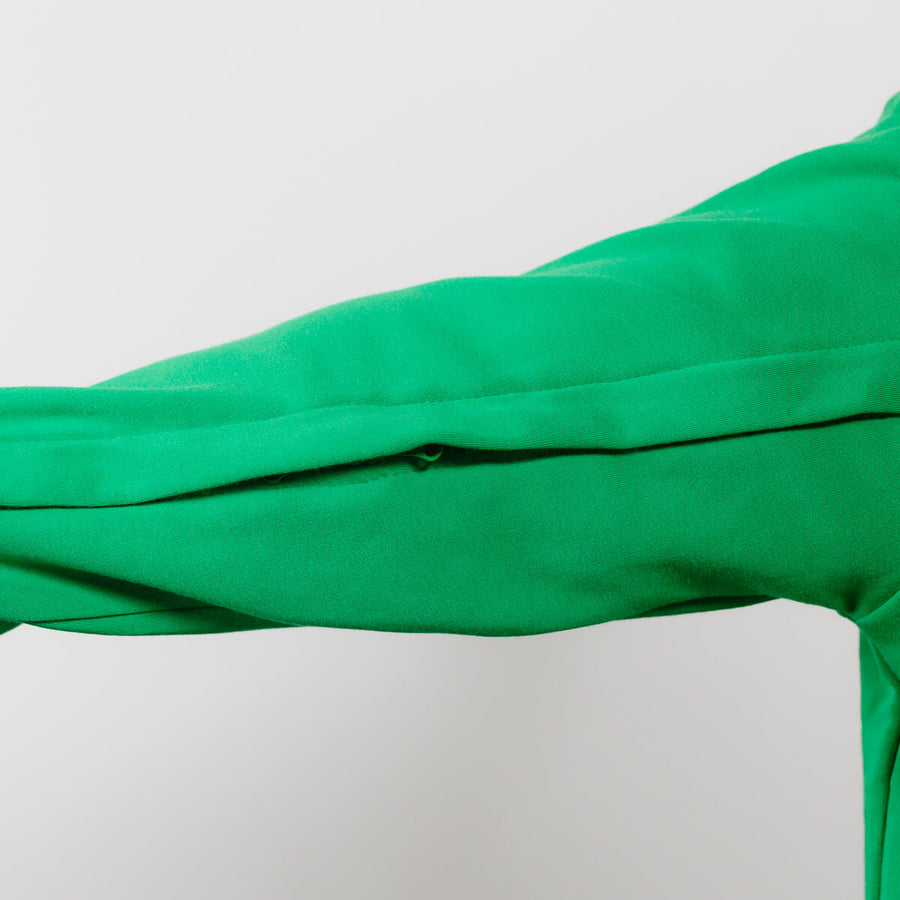 Close-up of green youth IV zip hoodie showing left arm zipper access detail.