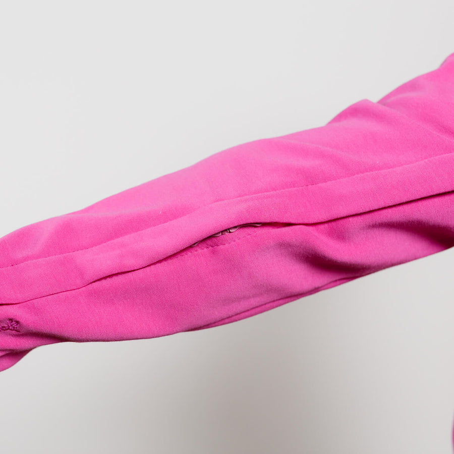Close-up of hot pink Youth IV zip hoodie sleeve showing fabric texture and zipper detail.