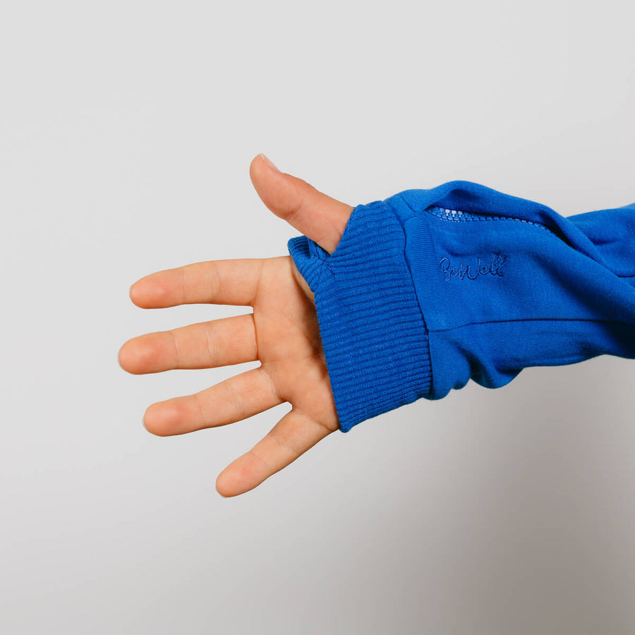 Child wearing royal blue IV zip hoodie with left sleeve zipper access feature visible.