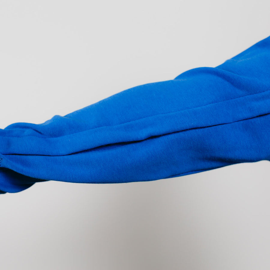 Close-up of blue Youth IV zip hoodie sleeve showing fabric texture and zipper detail.