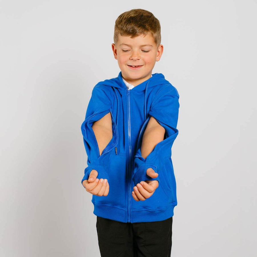 Young boy wearing a bright blue zip-up hoodie with cutout sleeves over black pants, smiling at camera. #NEW Child wearing a blue hoodie with cut-out sleeves on a plain background