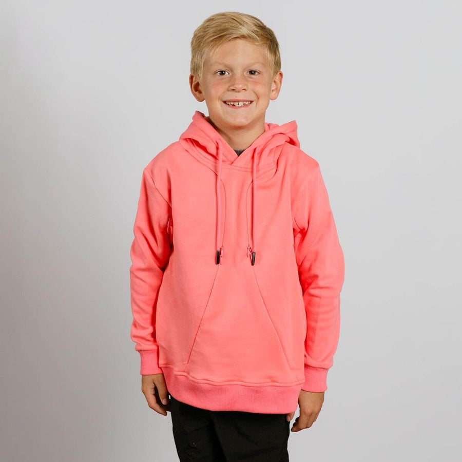Young boy wearing a bright coral pink hoodie with drawstrings, smiling at camera.