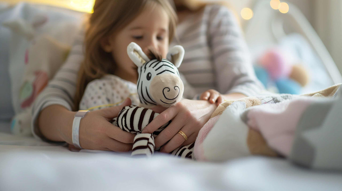 Young child holding a striped zebra toy while sitting with an adult.
