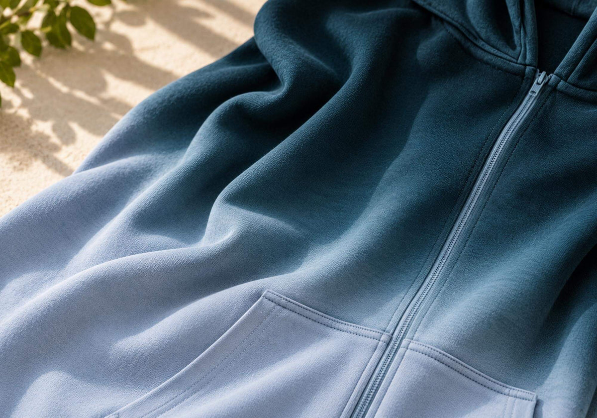 The hoodie's ombré fabric, deep navy fading into a softer blue