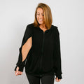 Woman wearing a black zip-up hoodie with cutout sleeves against a white background. #NEW Woman wearing a black hoodie with cut-out sleeves on a plain background | Model is 5'3" 130lbs wearing size S