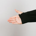 Person wearing black bamboo IV zip hoodie with left arm zipper access detail visible.