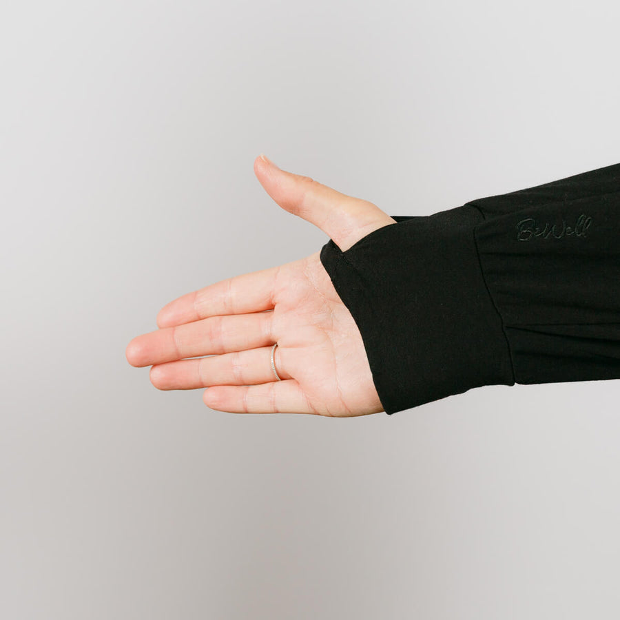 Person wearing black bamboo IV zip hoodie with left arm zipper access detail visible.