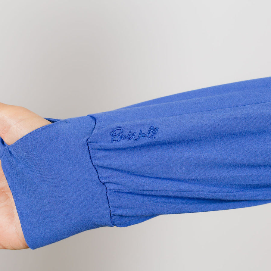 Person wearing blue bamboo IV zip hoodie with visible left sleeve zipper detail close-up.
