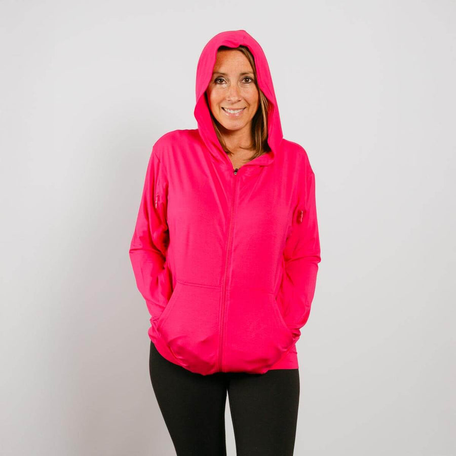 Woman wearing bright pink bamboo IV zip hoodie with hood up, front view.