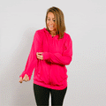 Woman wearing bright pink IV zip hoodie with front zipper, standing in lifestyle pose.