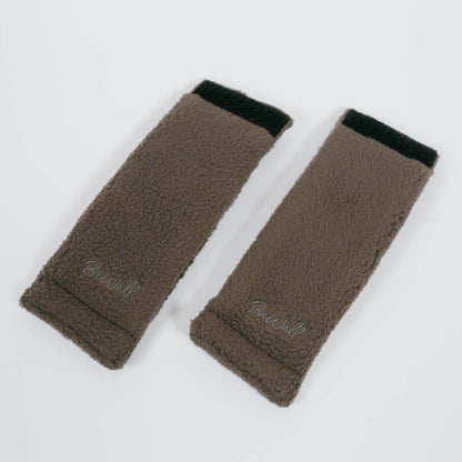 Two dark gray belt buffers or seatbelt port pads laid flat on a white surface.