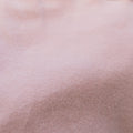 Close-up of blush pink IV zip hoodie fabric showing soft, textured material detail.