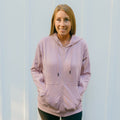 Woman wearing lavender zip hoodie with front zipper and kangaroo pocket, front view.