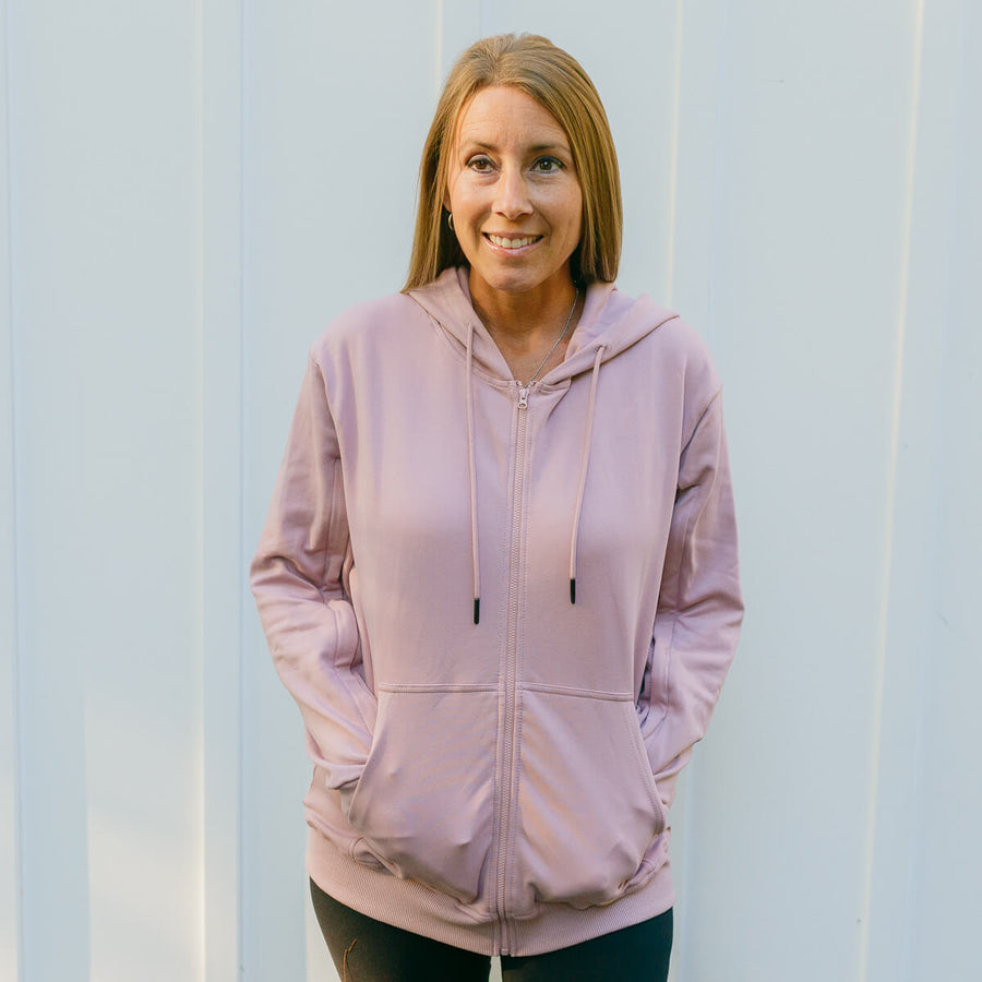 Woman wearing lavender zip hoodie with front zipper and kangaroo pocket, front view.