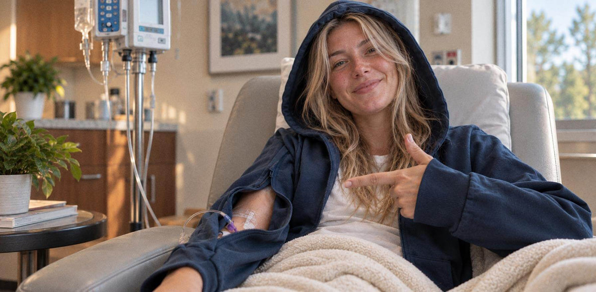 Patient in infusion chair wearing the BeWell IV Zip Hoodie
