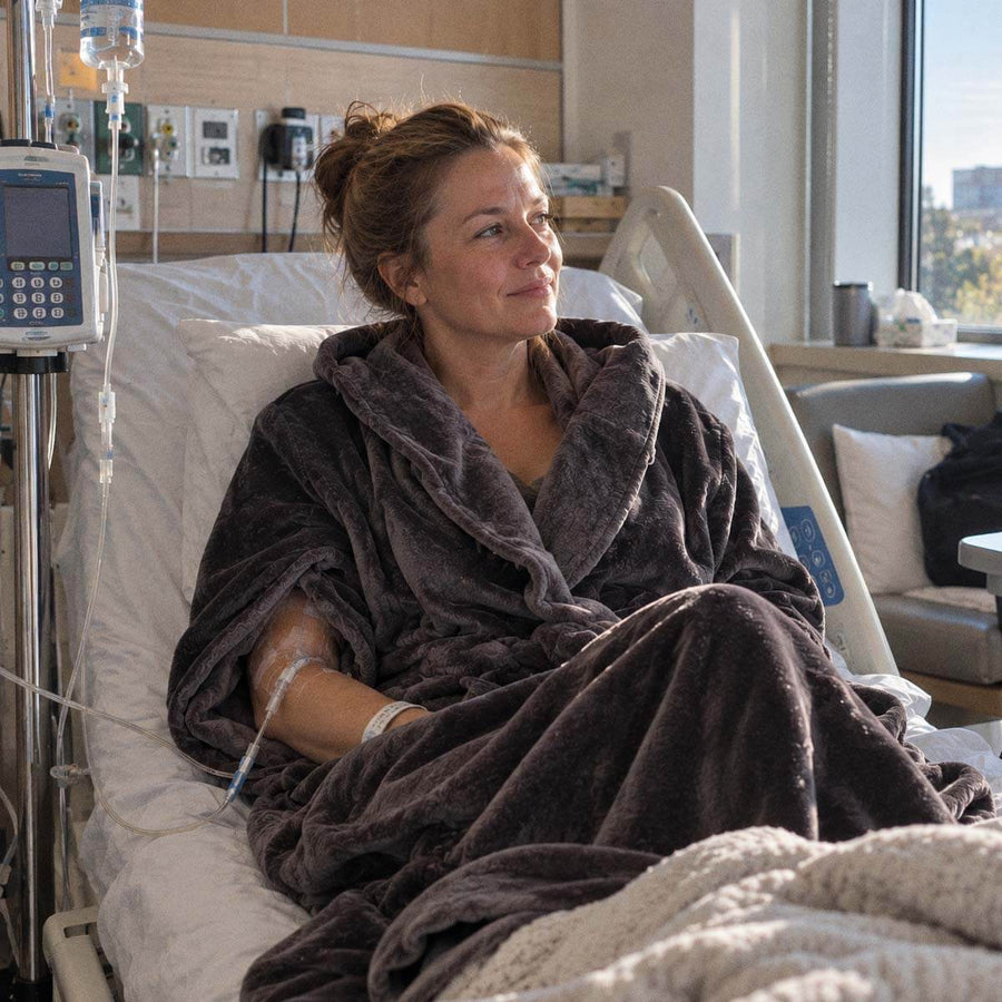 Woman wearing a plush IV access robe while receiving an infusion in a hospital bed