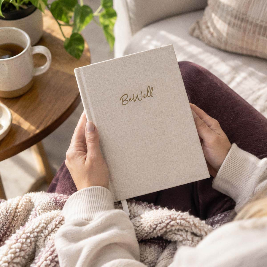Person relaxing at home with a BeWell IBD journal for tracking symptoms and daily health