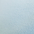 Close-up of light blue infusion blanket's soft, textured fabric surface.