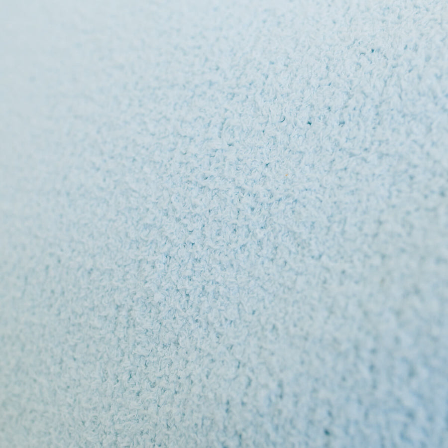 Close-up of light blue infusion blanket's soft, textured fabric surface.