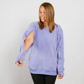 Woman wearing lavender crewneck sweatshirt with distressed cutout sleeves and black pants. | Model is 5'3" 130lbs wearing size S