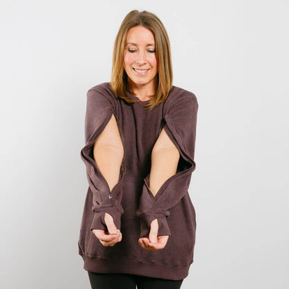 Woman wearing burgundy IV crewneck with open side zippers for medical access, front view.