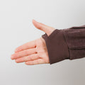 Person wearing brown IV crewneck with arm extended, showing accessible sleeve design detail.