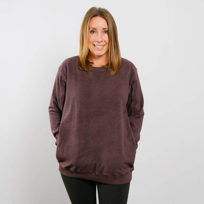 Woman wearing burgundy IV crewneck sweatshirt, front view, standing against white background.