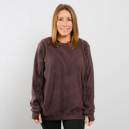 Woman wearing burgundy IV crewneck sweatshirt, front view.