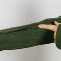 Close-up of olive green crewneck sleeve showing hidden zipper opening for IV access.