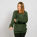 Woman wearing olive green IV crewneck, front view, looking down at arm access.