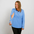 Woman wearing a light blue quarter-zip long-sleeve top with black pants against a white background.  | Model is 5'3" 130lbs wearing size S